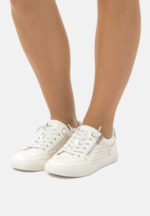 Zapatillas blancas perforadas con punteras redondas, diseño de cordones y un detalle de cremallera lateral. Textura suave con un acento plateado en contraste.