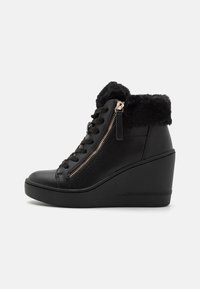 Bottines noires à talon wedge avec une tige en cuir texturé, fermeture à lacets et fermeture éclair sur le côté. Col en fourrure et talon wedge noir élégant.