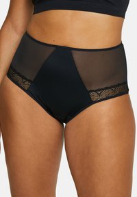Culottes noires taille haute avec des panneaux en maille et des accents en dentelle le long des bords, présentant un tissu lisse et un design structuré.