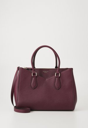 Bolso de mano de cuero púrpura oscuro con dos asas superiores, una correa para el hombro desmontable y detalle de cremallera dorada sobre un fondo liso.