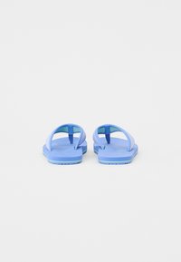 Blå flip-flops med tjock sula, som har två remmar. Det ljusblå övre kontrasterar med en mörkare sula och gröna detaljer. Slät textur.