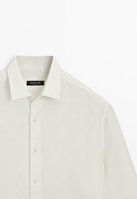 Biała koszula na długi rękaw z guzikami i klasycznym kołnierzykiem, wykonana przez Massimo Dutti, prezentowana na jednolitym białym tle.