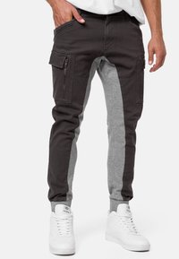 Herren-Jogginghosen mit einem dunklen grauen Oberteil und einem hellgrauen unteren Bereich, seitlichen Taschen, elastischen Bündchen und einer lässigen Passform.
