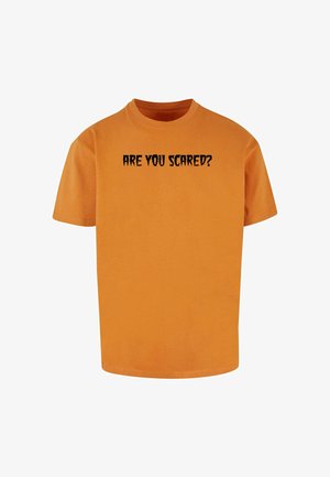 Narančasta pamučna majica s crnim ispisanim tekstom "JESI LI U BODE" u oštrim fontu. Kratki rukavi, okrugli izrez i opušteni kroj.