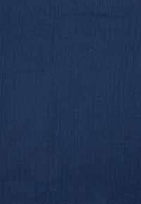 Dunkel marineblaues Gewebe mit glatter Textur. Das Material wirkt leicht und zeigt dezente vertikale Linien auf seiner Oberfläche.