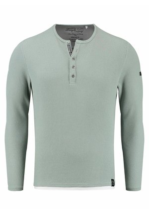 Lichtgroene langermige henley-shirt met een geribbelde textuur, drieknoopsluiting en zwarte accenten bij de zoom. Zachte stof. Maat S.