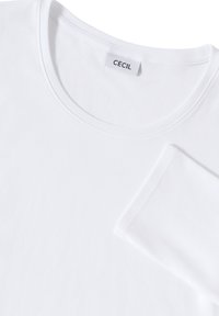 Camiseta blanca de manga corta con cuello redondo, hecha de algodón suave, que presenta una etiqueta y una textura lisa. Diseño simple y liso.