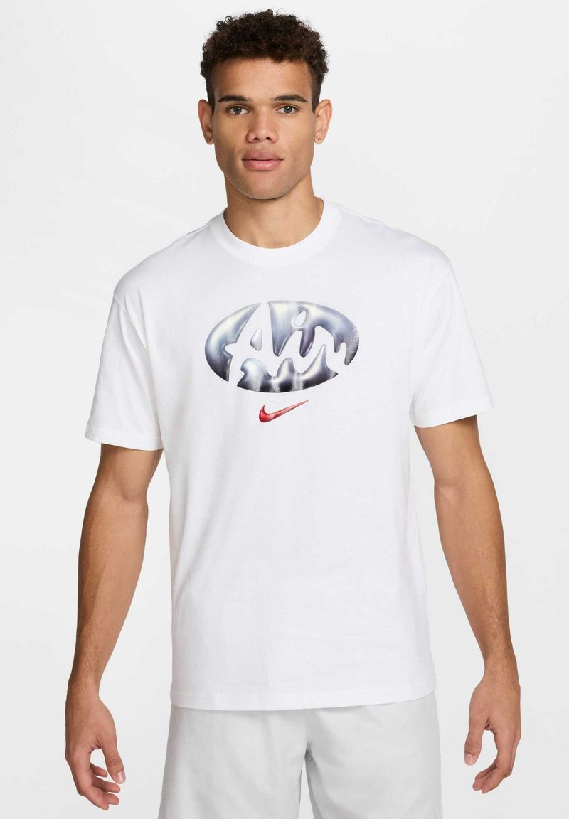 T-shirt en coton blanc mettant en avant un grand logo "Air" argent et noir ainsi qu'un petit swoosh rouge de Nike. Manches courtes, col rond.