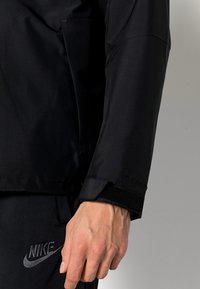 Nike Sportswear Vandeniui atspari striukė - black/black