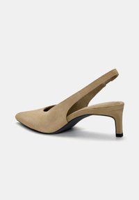 Tacco slingback in suede beige con punta affusolata, design slanciato e tacco nero sottile. Presenta un dettaglio a taglio sul lato superiore.