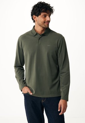 Long-sleeve olive green polo shirt with a buttoned collar, features embroidered logo on the left chest, paired with dark jeans.