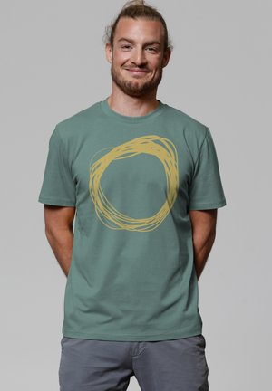 Groene katoenen t-shirt met een gele cirkelvormige grafisch ontwerp. Korte mouwen, ronde hals en een relaxed fit.