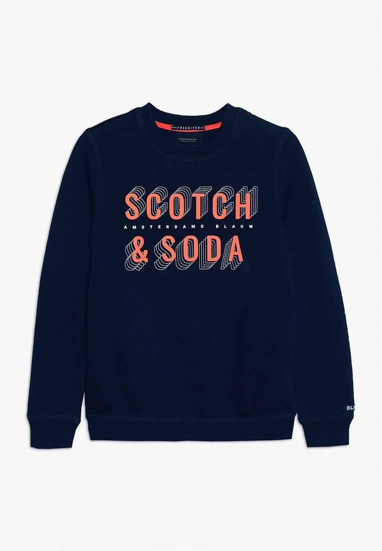 Sweatshirt bleu marine en tissu doux, avec un col rond, des poignets côtelés, et un imprimé graphique en orange et blanc portant les mots "SCOTCH & SODA."