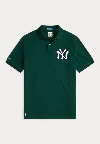 Zaļš kokvilnas polo krekls ar baltu NY logo kreisajā krūtī un mazu baltu ponija logo uz apakšmalas. Klasisks dizains ar apkakli.