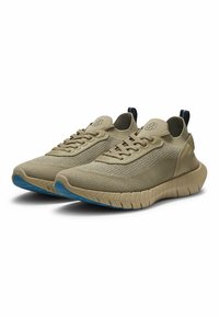 Beige Sportschuhe mit atmungsaktivem Mesh-Obermaterial, dicker Sohle und blauem Akzent an der Außensohle; verfügt über traditionelle Schnürung und eine Lasche zum Anziehen.