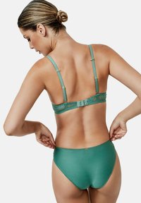 Groene lingerie set met een met kant afgewerkte beha met verstelbare schouderbandjes en bijpassende hoge taille slip, met een soepele textuur.