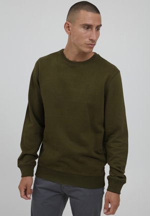 Olijfgroen sweatshirt van een zachte stof, met een ronde hals, geribbelde manchetten en een klein logo op de borst, gecombineerd met grijze broeken.