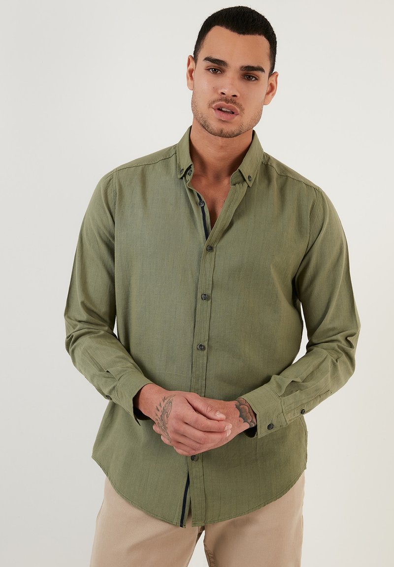 Koszula z długim rękawem w oliwkowym kolorze, slim fit, kołnierz zapinany na guziki, teksturowana tkanina, zapięcie z przodu z ciemnymi guzikami, zaokrąglony dół.