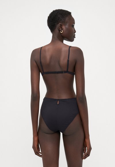 Black bikini set featuring adjustable straps, a back closure, and high-waisted bottom with a cut-out detail. Smooth fabric finish.