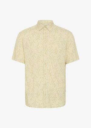 Kratka majica s kratkimi rokavi v svetlo rumeni tkanini z diskretnim vzorcem listov, s kragnico in gumbom spredaj. Mehka tekstura in sproščen kroj.
