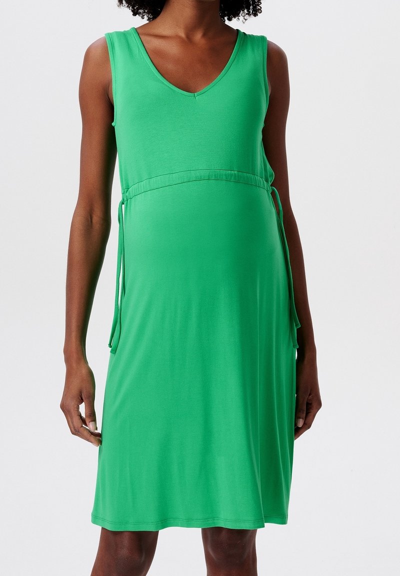 Vestido de maternidad verde en tejido suave, sin mangas, con escote en V, lazo ajustable en la cintura y un corte holgado.
