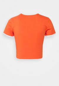 T-shirt orange court à manches courtes, avec un col rond et un liseré blanc sur les bords des manches. Tissu en coton doux.