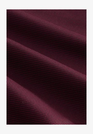 Burgundia tekstuuriga kangas, millel on ruuduline muster, millel on kerge läige ja kootud tekstuur, näidates sügavust ja mõõtmeid voldikutes.