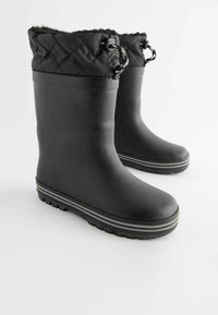 Bottes de pluie en caoutchouc noires avec une texture matelassée en haut, dotées d'une fermeture à cordon de serrage et d'une semelle rayée grise pour une meilleure adhérence.