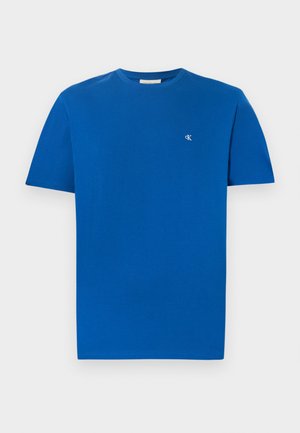 Blå bomuld T-shirt med rund halsudskæring og korte ærmer. Har en lille hvid logo på venstre bryst. Glat tekstur, afslappet design.