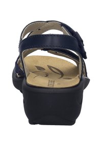 Tyrkysové sandály s pevnou černou podrážkou, otevřenou zadní částí a několika nastavitelné pásky. Polstrovaná stélka s květinovým vzorem.