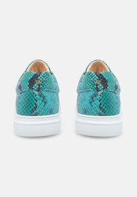Türkise Sneaker im Schlangenprint mit weißen Gummisohlen und strukturierten Oberflächen. Sie verfügen über ein glattes Innenfutter und ein minimalistisches Design ohne Schnürsenkel.