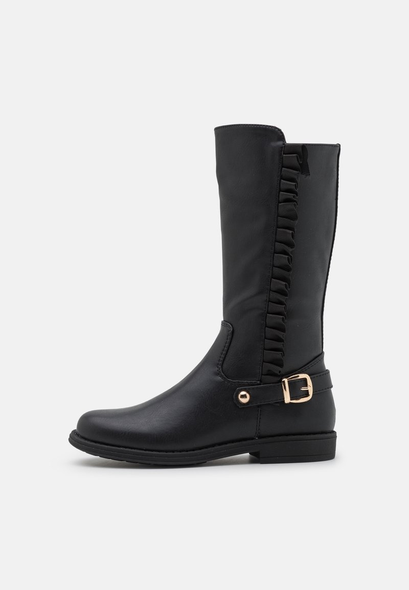 Botte noire mi-mollet avec bordure à volants sur le côté et une bride à boucle dorée près de la cheville, semelle plate avec un léger talon.