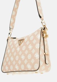 Sac à main synthétique beige avec des motifs géométriques blancs, quincaillerie dorée et une plaque de logo. Dispose d'une bandoulière détachable et d'une surface texturée.