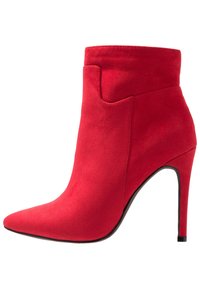 Stivale alla caviglia in suede rosso con punta affilata, tacco a spillo alto e design del gambale curvo. Texture liscia, senza hardware o motivi visibili.