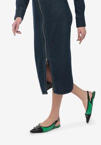 Bailarinas slingback negras y verdes con punteras puntiagudas, que presentan una parte superior verde brillante y acentos de cuero negro. Vestido de mezclilla con cremallera hasta la rodilla.