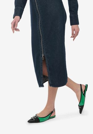 Des ballerines noires et vertes avec un bout pointu, présentant une tige verte brillante et des accents en cuir noir. Une robe en denim à zip jusqu'au genou.