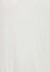 Lehký bílý svetr s jemnou texturou a jednoduchým designem, který má výstřih do V a žádné viditelné vzory ani ozdoby.