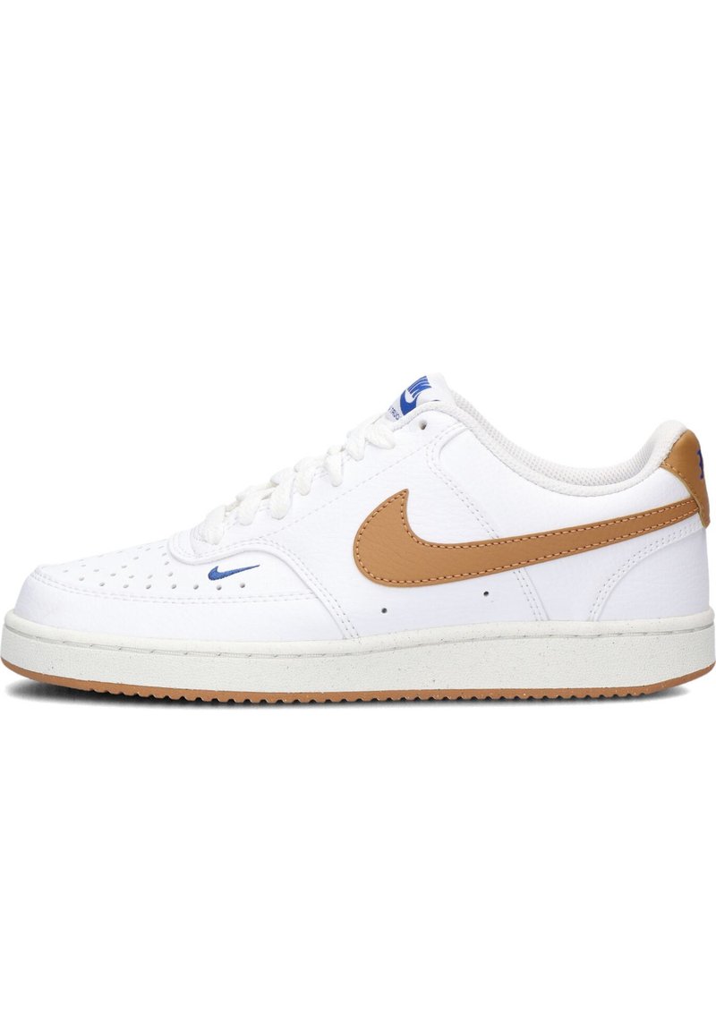 Zapatilla blanca con una parte superior de cuero texturizado, swoosh de cuero marrón y logo azul. Presenta perforaciones en la puntera y una suela de goma.