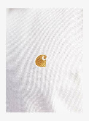 Fehér szövet textúrázott befejezéssel, amelyen egy kis arany hímzett logó látható, amely egy stilizált "C" betűt formáz az alsó sarokban.