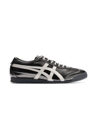 Sneaker bianco e nero con tomaia in pelle liscia, caratterizzato da strisce distintive e una suola in gomma testurizzata. Design con lacci e profilo basso.