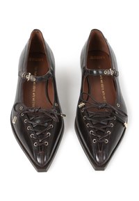 Bailarinas de cuero marrón con punta afilada, cordones en la parte delantera, tira de tobillo con hebilla y acentos de metal. Textura suave.
