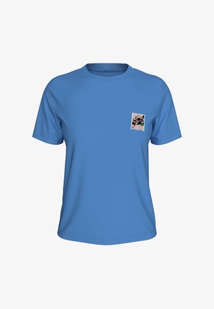 Μπλε κοντομάνικη μπλούζα με μικρό ασπρόμαυρο λουλουδάτο σχέδιο στην αριστερή πλευρά του στήθους.