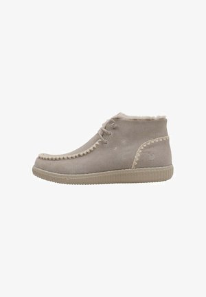 Bottes de cheville en suède gris clair avec une semelle en caoutchouc texturée, des coutures décoratives le long du bord et une doublure en fausse fourrure douce sur le haut.