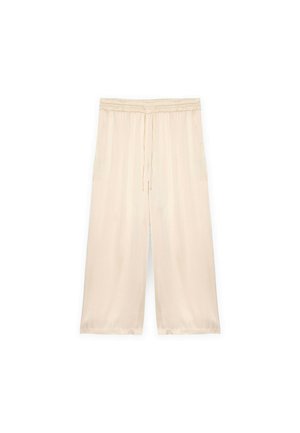 Hellbeige, weit geschnittene Hose mit elastischem Bund und Kordelzug. Weicher, glatter Stoff mit Seitentaschen. Knielange.