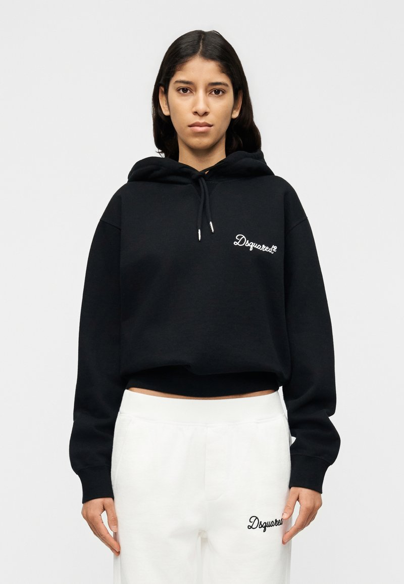 Sweat à capuche noir court avec poche avant et logo "Dsquared2" brodé, associé à un pantalon de survêtement blanc arborant une broderie assortie.