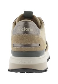 Baskets de sport beiges avec un dessus en daim et en synthétique, dotées d'une semelle rembourrée, d'un dos texturé et d'un détail de logo gravé.