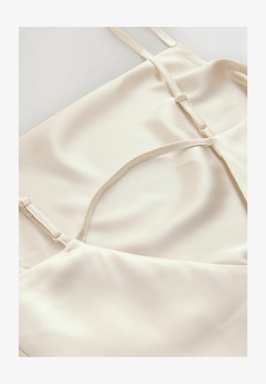 Camisole din satin crem cu bretele subțiri, având o decupare în formă de cheie în partea din față și cusături plate pentru un finisaj neted.