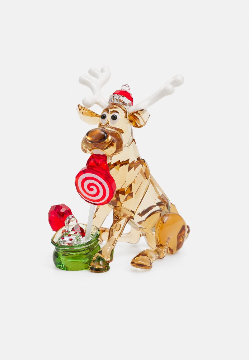 Figurina di renna in cristallo con tonalità chiare e ambra, con corna bianche e una leccornia rossa e bianca in un contenitore verde.