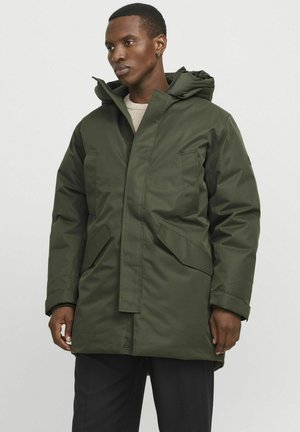 Parka verde, aislante, con capucha, que presenta una cremallera frontal, dos bolsillos laterales y un diseño de longitud media. Textura de tela lisa y sólida.
