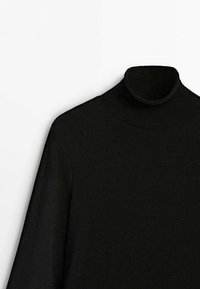 Pull à col roulé noir avec manches longues, texture côtelée et design ajusté. Tissu doux avec des détails de couture minimalistes.